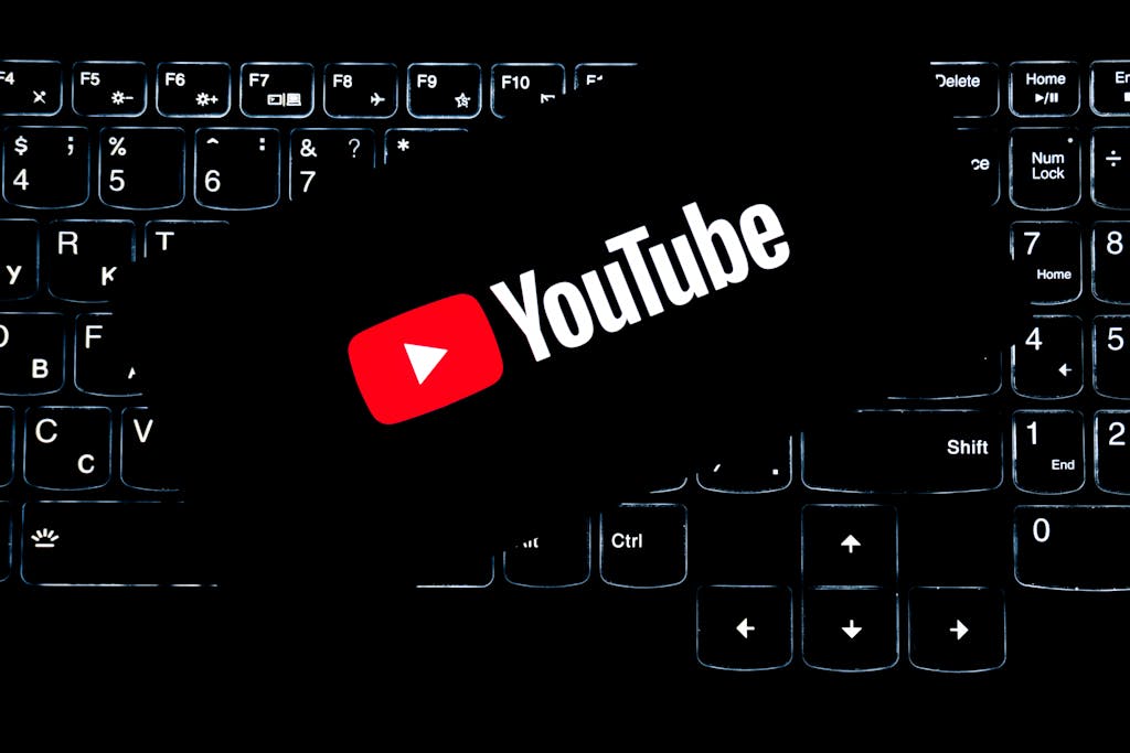 YouTube logo displayed on a backlit keyboard, representing digital media and online content creation.